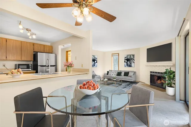 a kitchen with kitchen island granite countertop a stove a oven a dining table and chairs with wooden floor