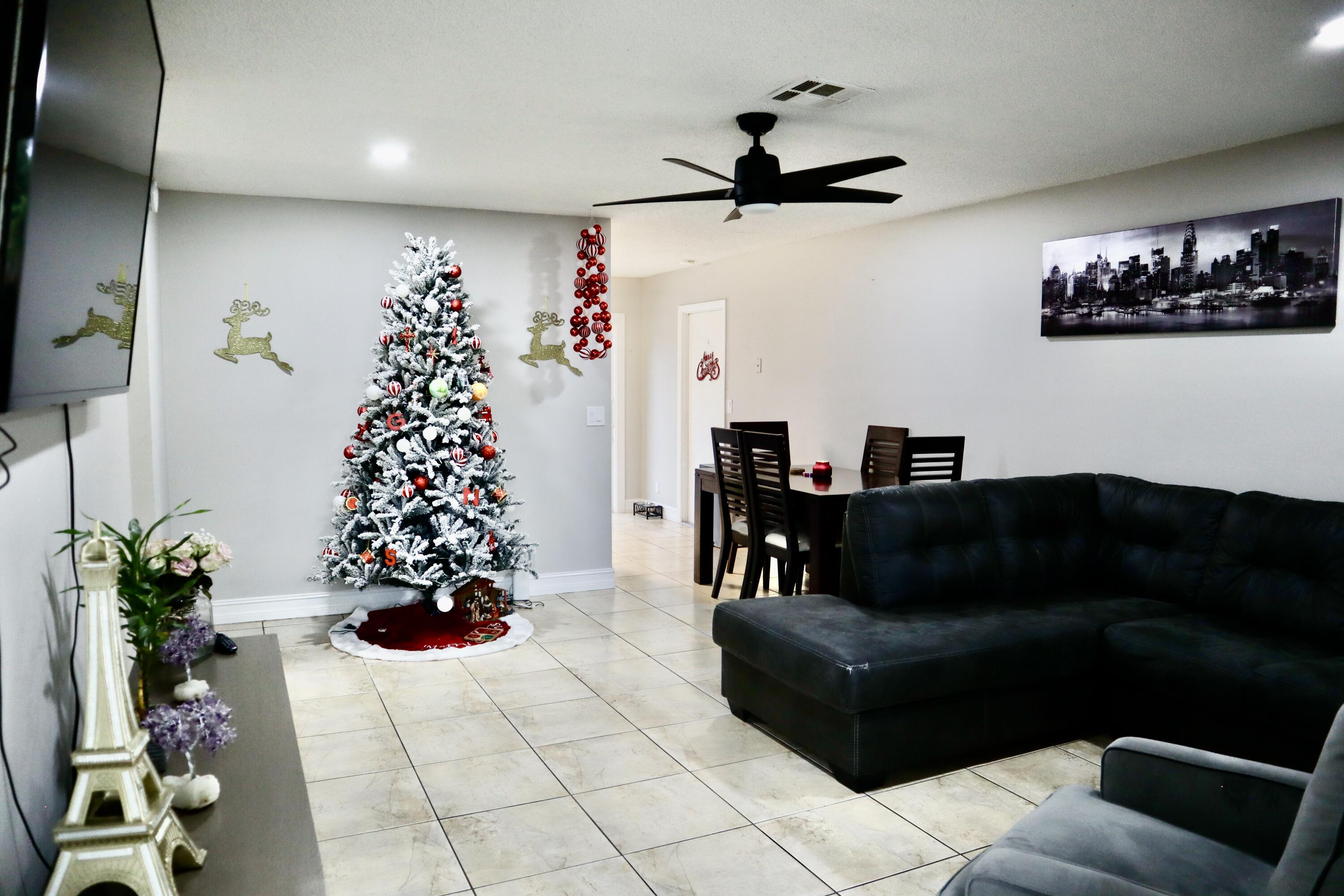 5905 Triphammer Road Lake Worth, FL 33463 - Photo 2 of 8 a living room with furniture and flowers
