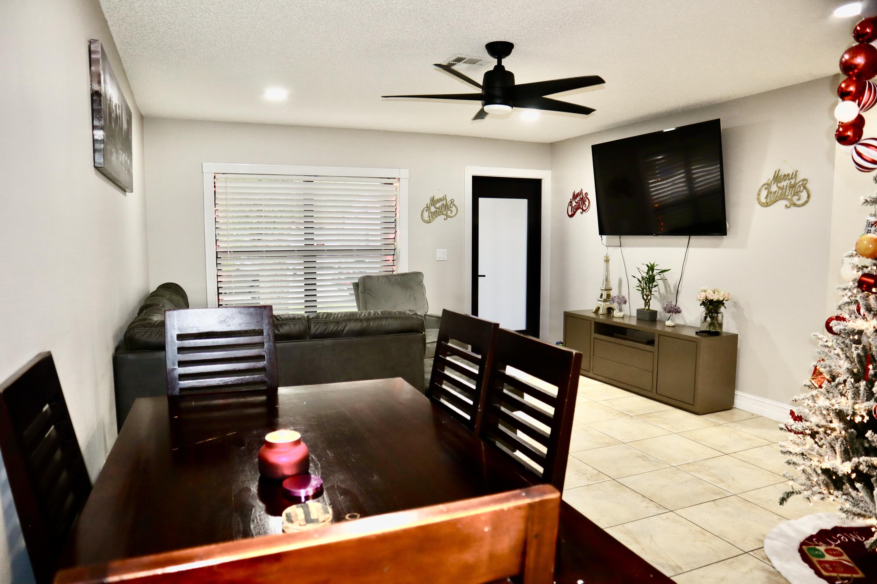 5905 Triphammer Road Lake Worth, FL 33463 - Photo 3 of 8 a living room with furniture and a flat screen tv