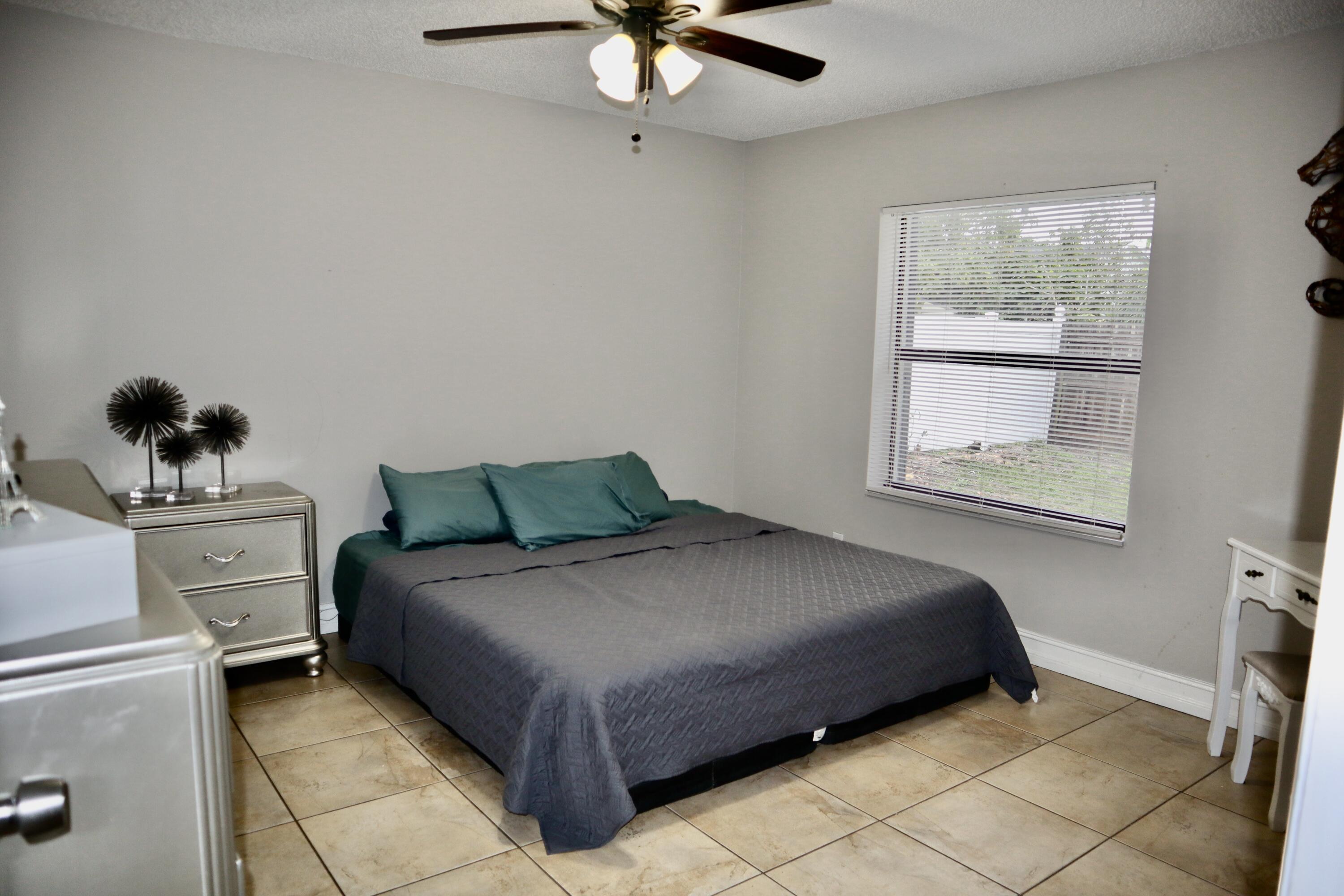 5905 Triphammer Road Lake Worth, FL 33463 - Photo 5 of 8 a bedroom with a bed and window