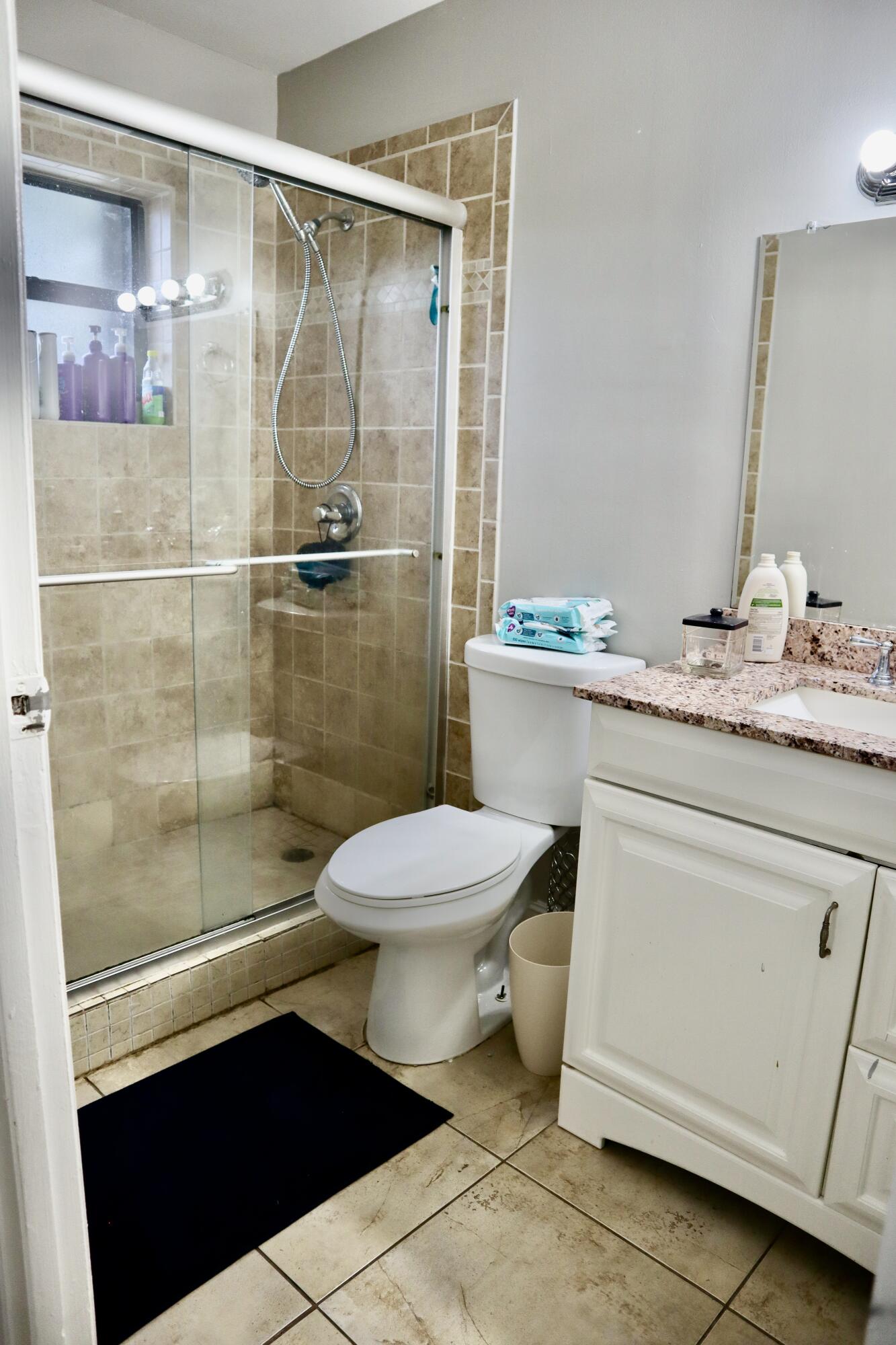 5905 Triphammer Road Lake Worth, FL 33463 - Photo 6 of 8 a bathroom with a toilet a sink and shower