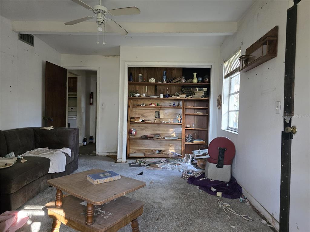 1124 South Wiggins Road Plant City, FL 33566 - Photo 3 of 7 a living room with furniture a window and bookshelf