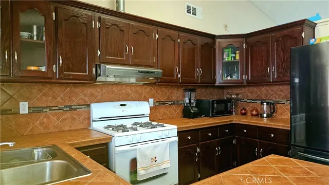 a kitchen with a sink a stove and cabinets