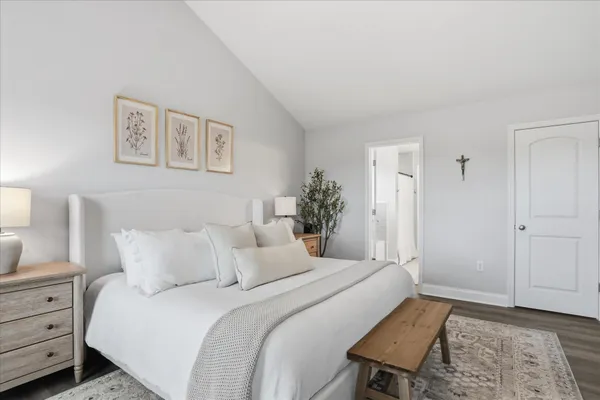a bedroom with a bed and a lamp on dresser