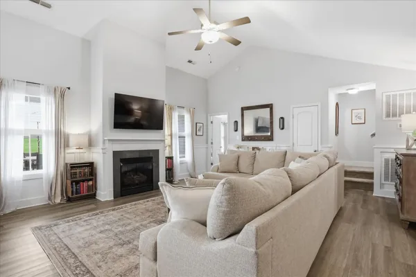 a living room with furniture a fireplace and a flat screen tv