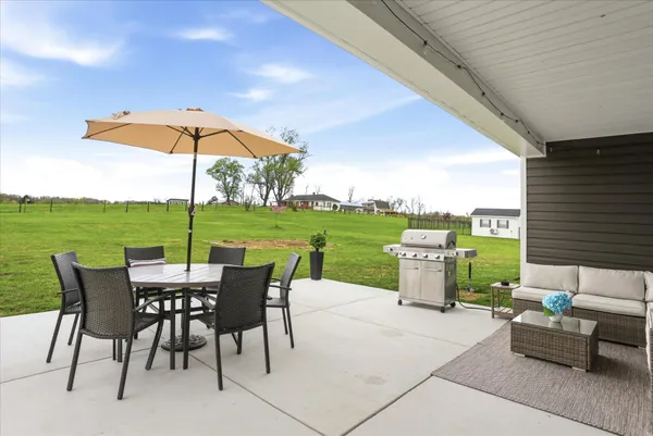a view of a patio with a table and chairs under an umbrella