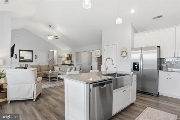 a kitchen with sink a refrigerator and white cabinets