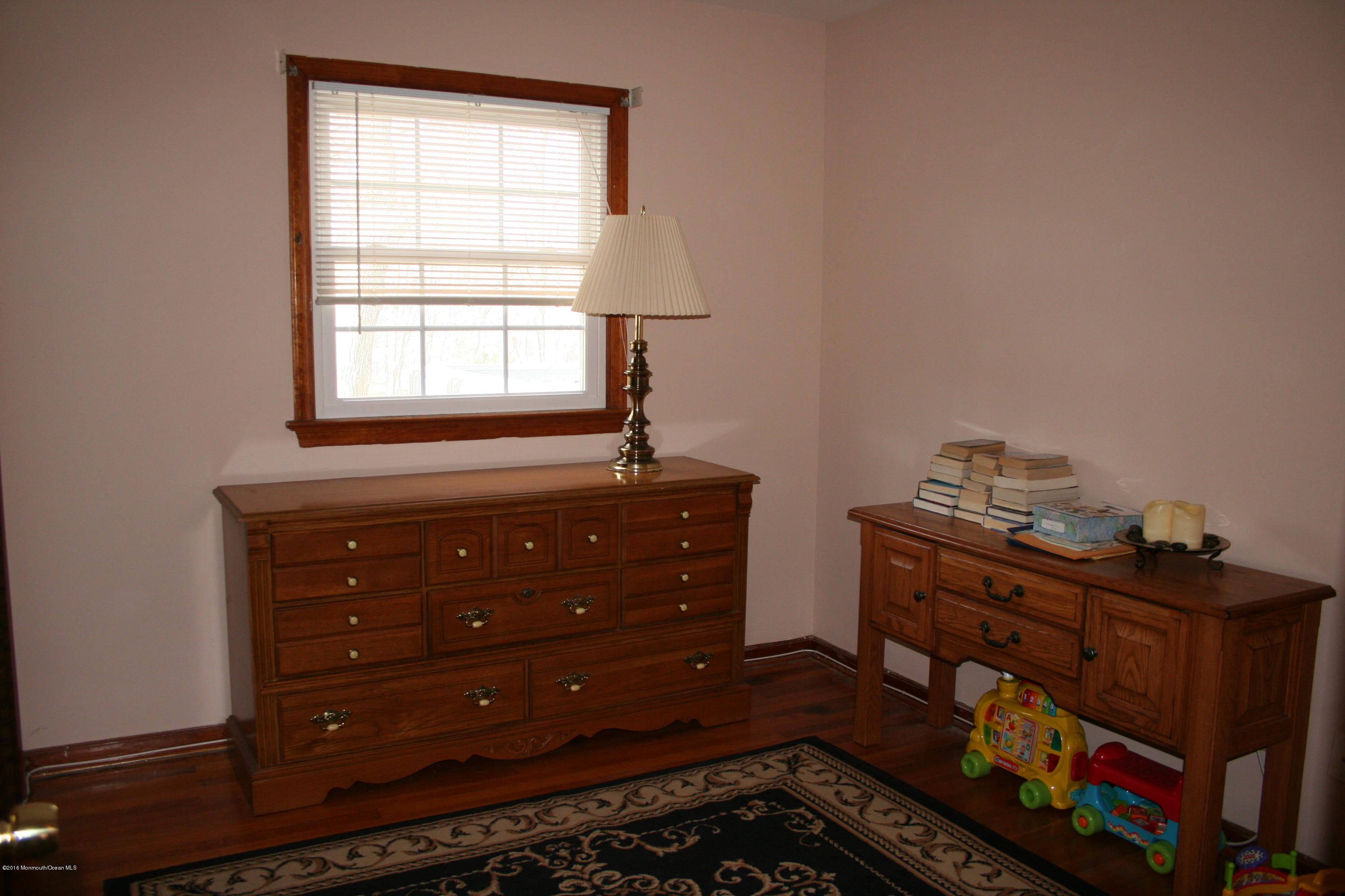 129 Aberdeen Road Aberdeen, NJ 07747 - Photo 14 of 28 a room with a dresser and a window