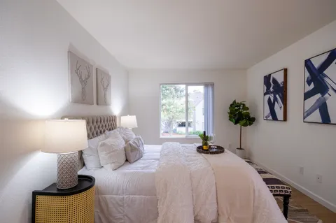 a bedroom with a bed and painting on the wall