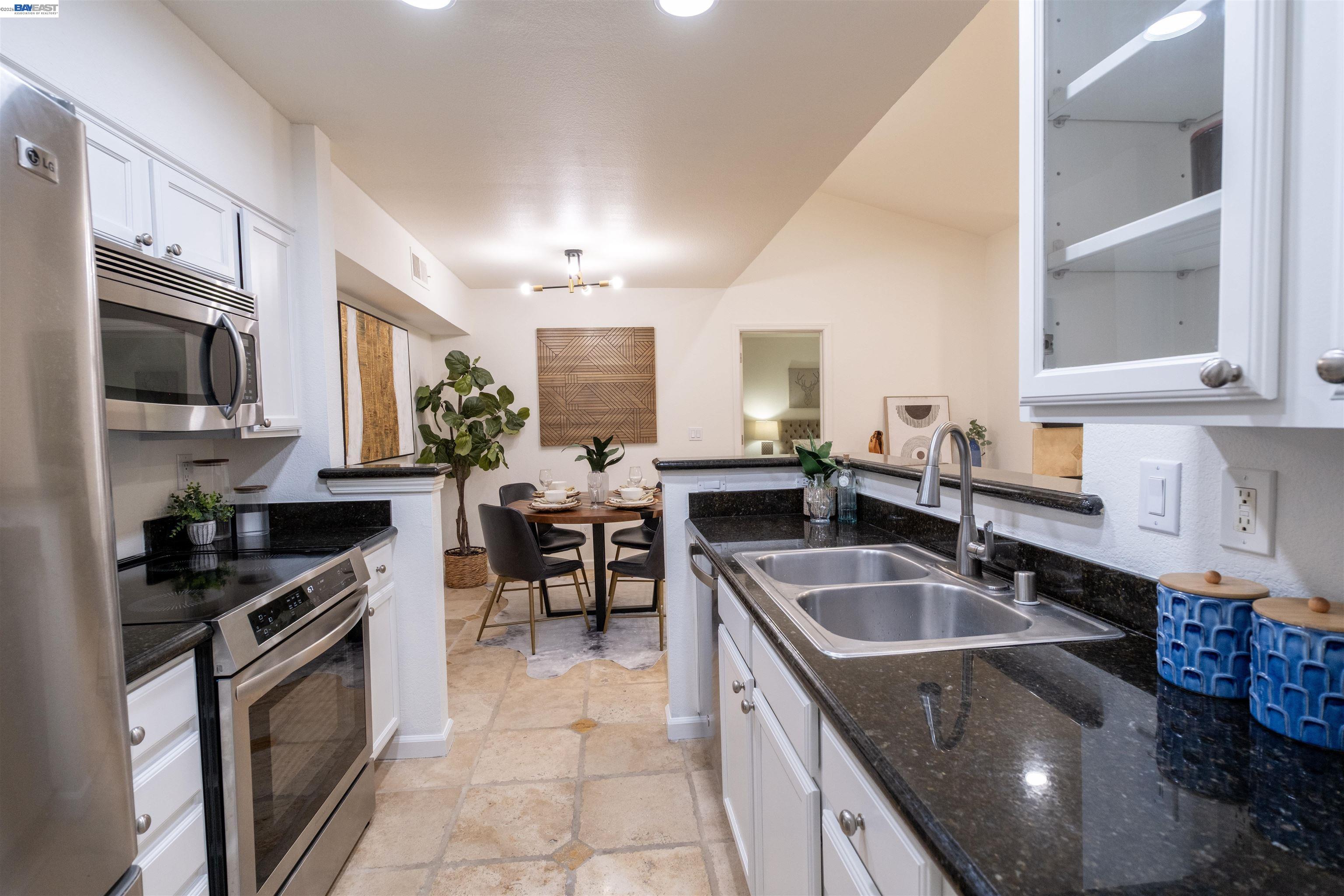 285 Reflections Drive, Unit 23 San Ramon, CA 94583 - Photo 5 of 34 a kitchen with granite countertop a sink stainless steel appliances a counter space and cabinets