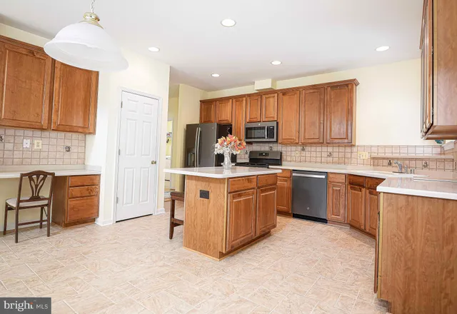 a living room with stainless steel appliances kitchen island granite countertop a stove and a view of living room