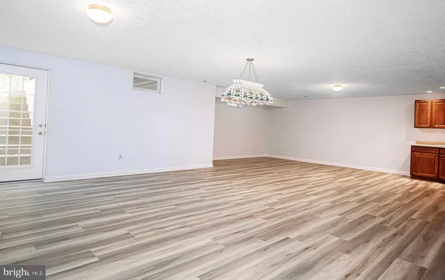 a view of a house with a small yard and a large tree