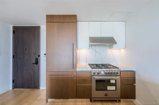 a kitchen with cabinets and steel appliances