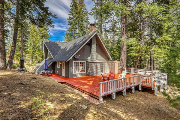 a view of a house with a wooden deck and a yard