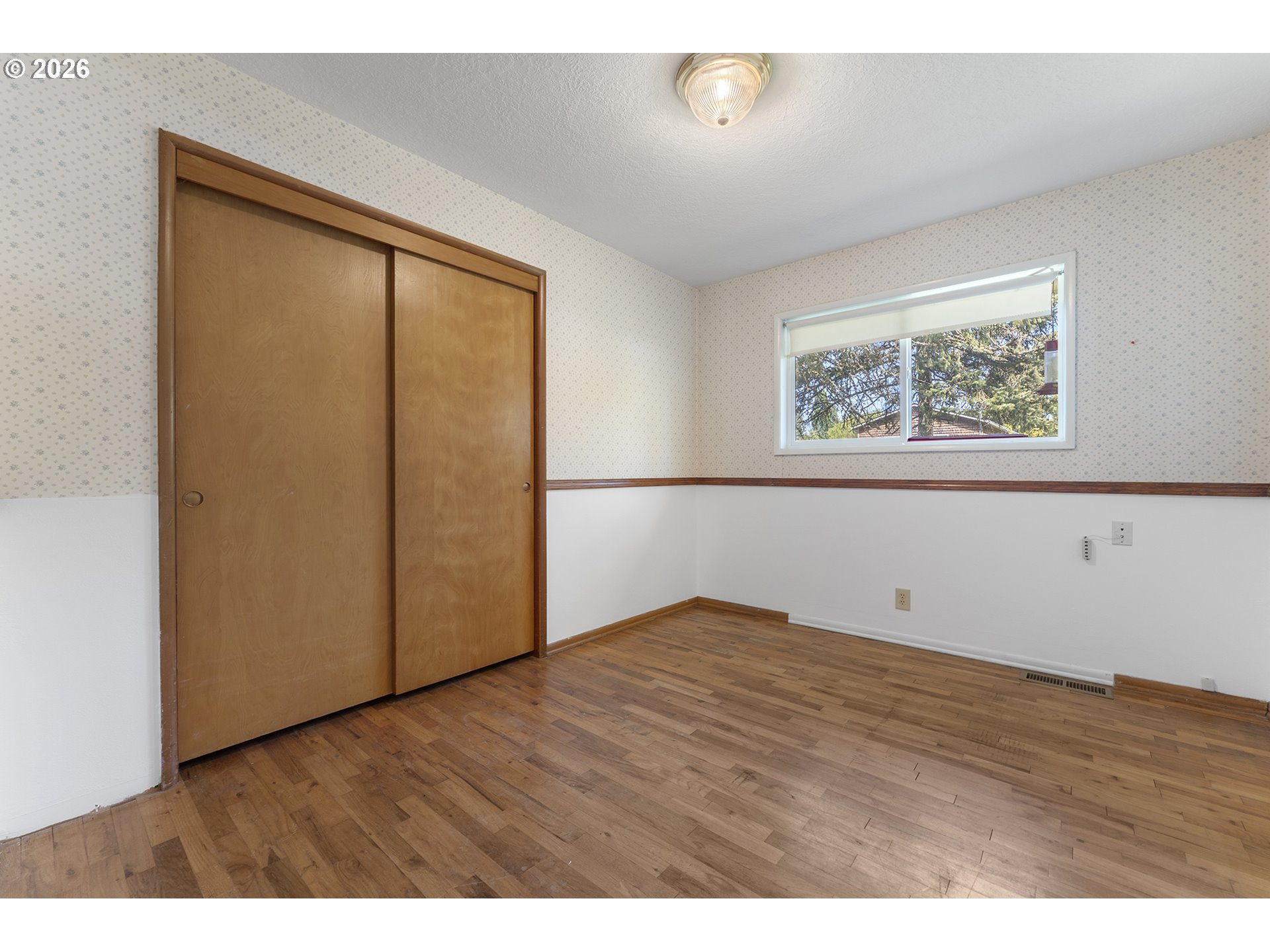 4355 Southwest 188th Avenue Beaverton, OR 97078 - Photo 24 of 42 a view of an empty room with wooden floor and a window