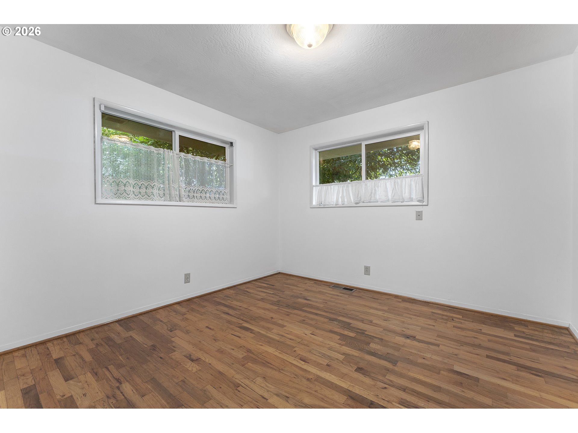 4355 Southwest 188th Avenue Beaverton, OR 97078 - Photo 25 of 42 a view of an empty room with wooden floor and a window