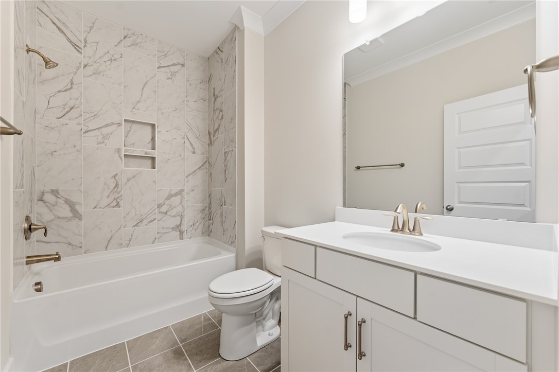 203 Timothy Court Anderson, SC 29621 - Photo 15 of 40 A refined bath with a sleek white vanity and a shower-tub combination featuring elegant tiled walls.