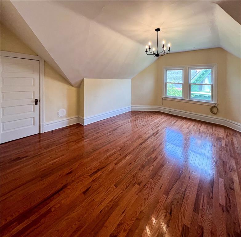 926 Savannah Avenue, Unit 3 Pittsburgh, PA 15221 - Photo 2 of 13 an empty room with wooden floor chandelier and windows