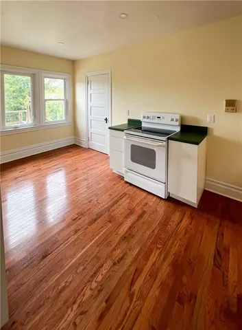 an empty room with wooden floor and white walls