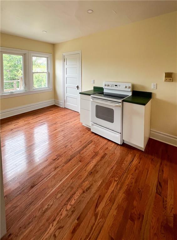 926 Savannah Avenue, Unit 3 Pittsburgh, PA 15221 - Photo 5 of 13 an empty room with wooden floor and white walls