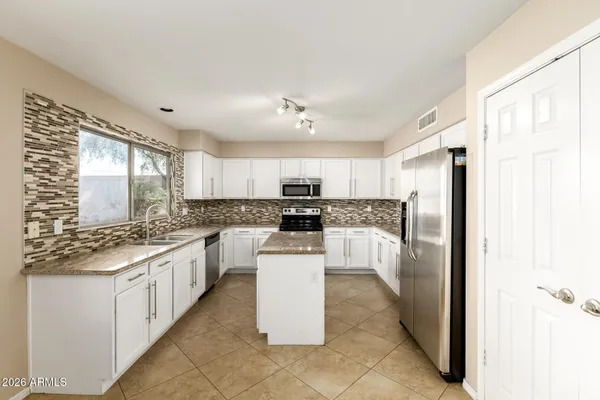 a kitchen with a sink a counter top space stainless steel appliances and cabinets