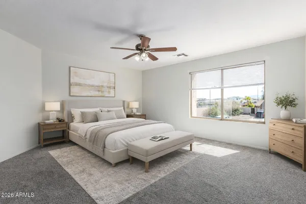 a spacious bedroom with a bed couch and window