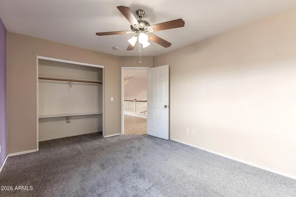an empty room with a window and a ceiling fan