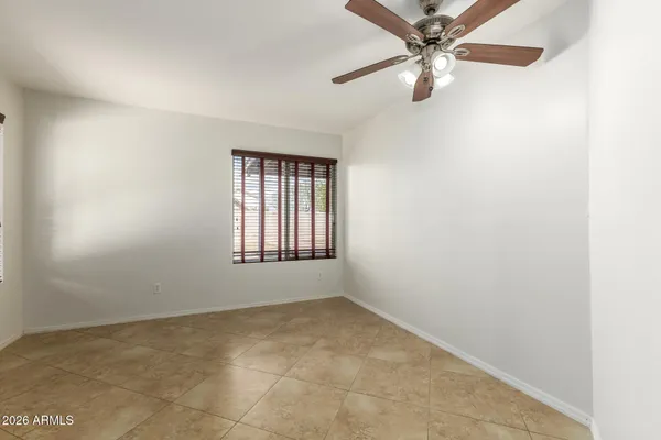an empty room with a window and a fan