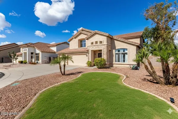 a view of a white house with a big yard and potted plants