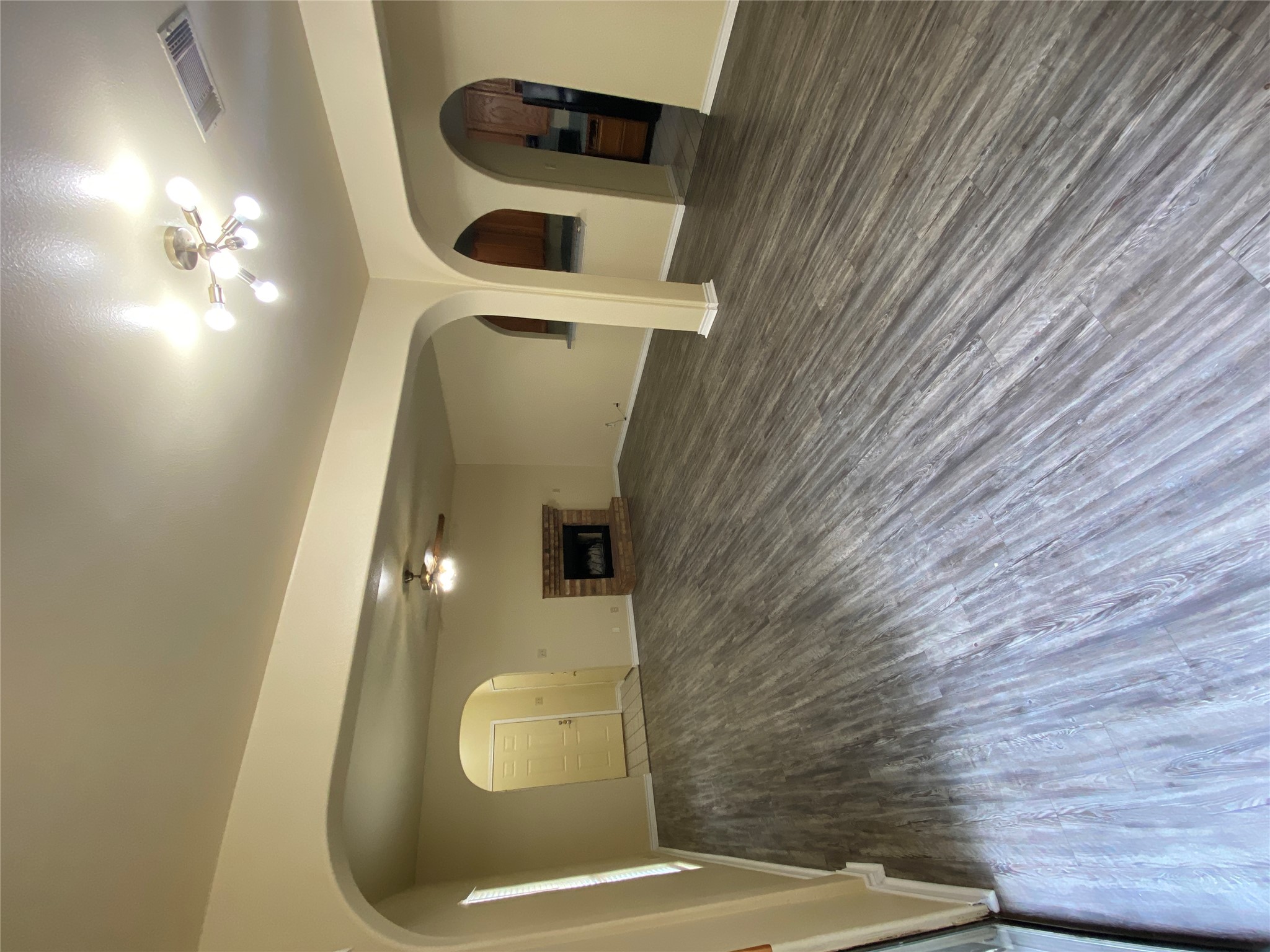 The spacious living area features wide plank flooring and a cozy fireplace.