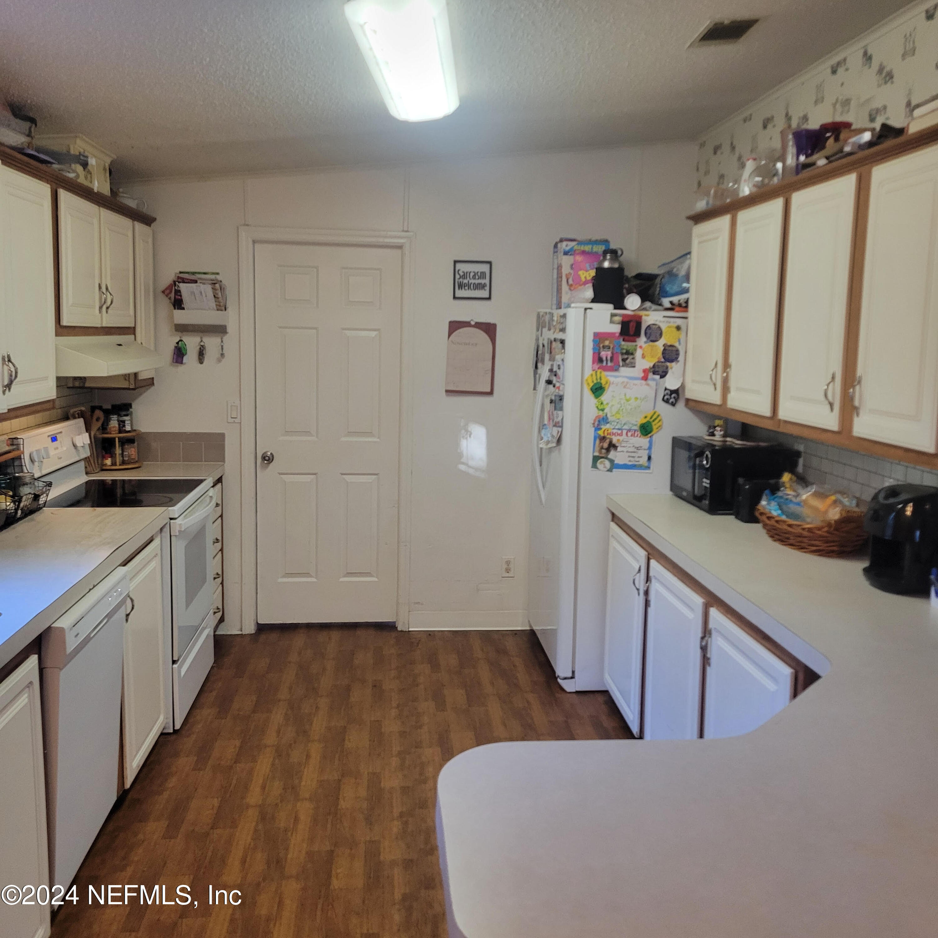 7616 Townsend Road Jacksonville, FL 32244 - Photo 13 of 38 a kitchen with a sink a refrigerator and cabinets