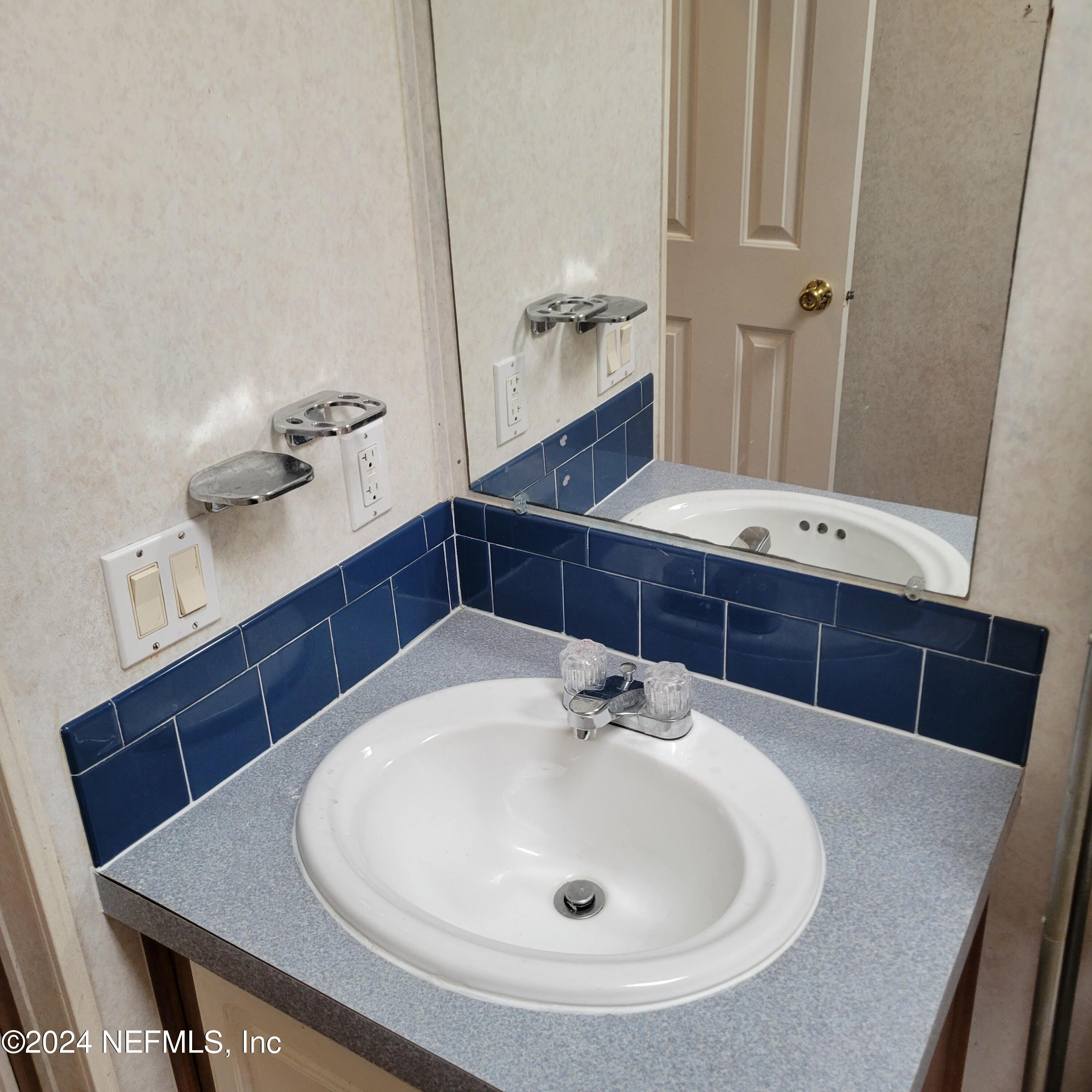 7616 Townsend Road Jacksonville, FL 32244 - Photo 37 of 38 a bathroom with a sink and a mirror