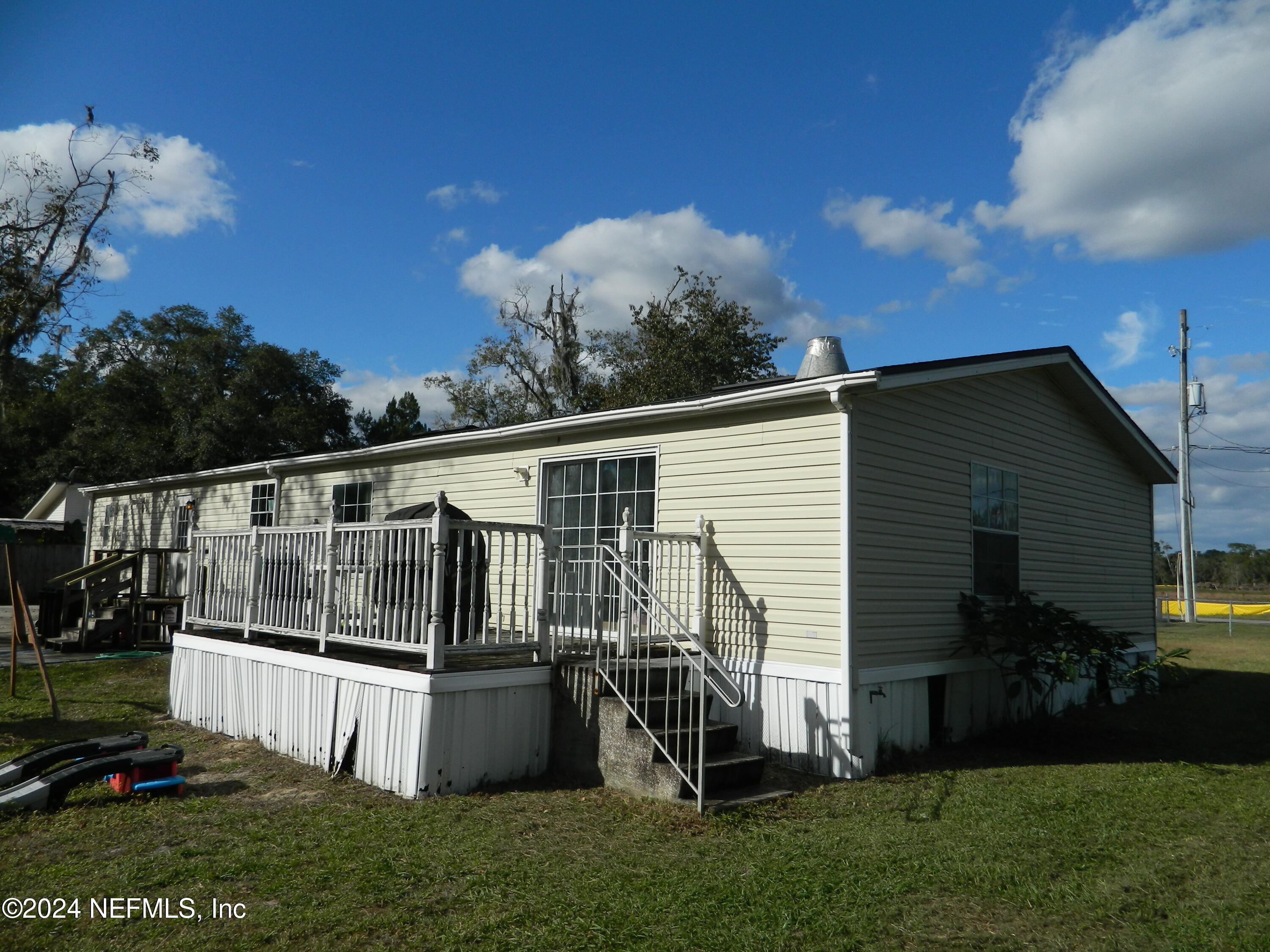7616 Townsend Road Jacksonville, FL 32244 - Photo 5 of 38 a view of a white house with a big yard and potted plants