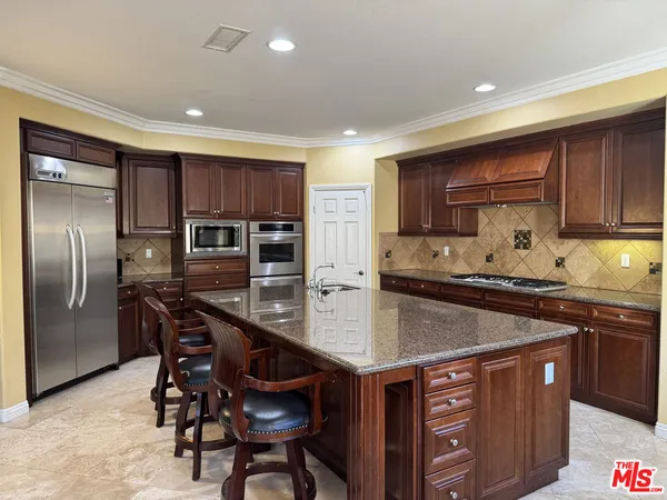 a kitchen with stainless steel appliances granite countertop a stove a sink a microwave and a refrigerator