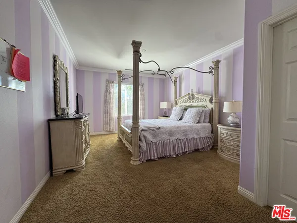 a bedroom with a bed next to a window