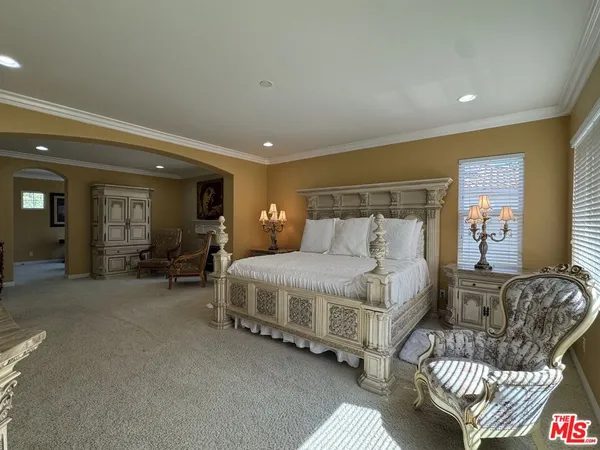 a bedroom with bed and a large window