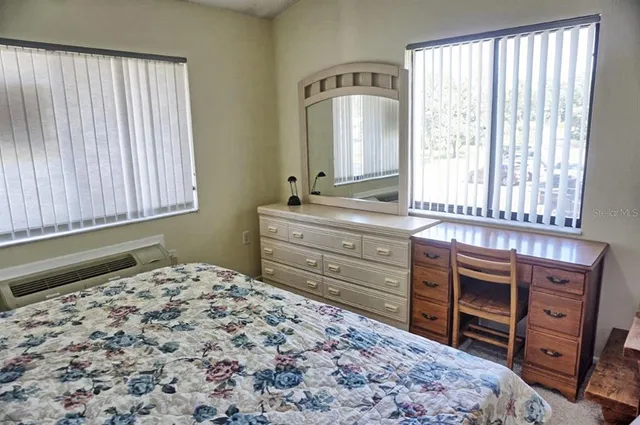 a room with a bed and a mirror on dresser