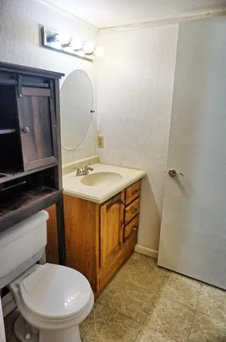 a bathroom with a sink a toilet a mirror and vanity