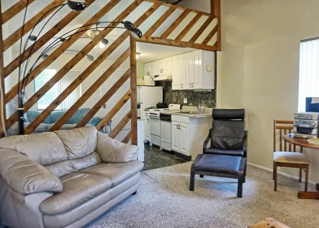 a living room with furniture a rug and white walls