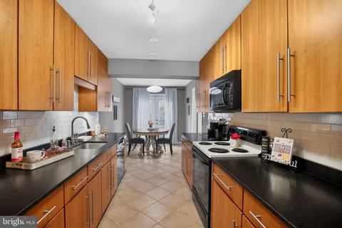 a kitchen that has a lot of cabinets a sink and appliances in it