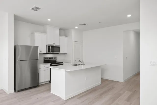 a kitchen with stainless steel appliances a refrigerator stove microwave and sink