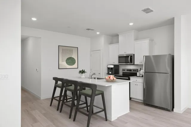 a kitchen with stainless steel appliances a refrigerator and a stove top oven