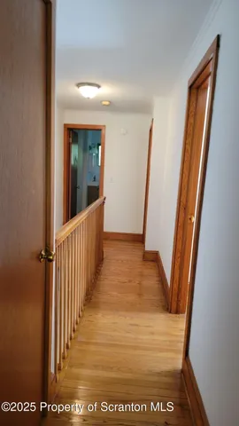 a view of a hallway with wooden floor and stairs