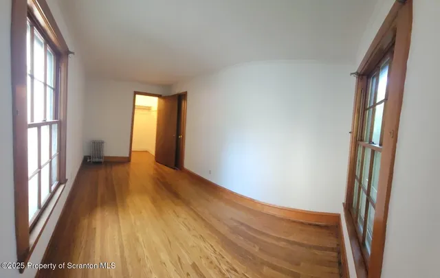 a view of a room with wooden floor and window