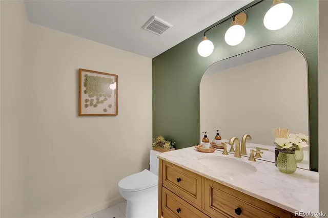 a bathroom with a granite countertop sink mirror and toilet