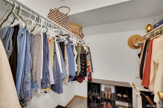 a view of walk in closet with clothes and shoes