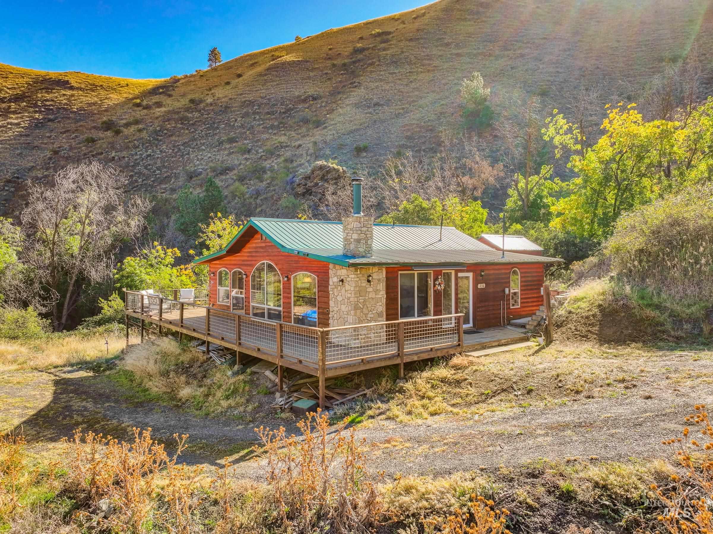 236 Seven U Ranch Road Lucile, ID 83542 - Photo 26 of 26 Rear view of property featuring a deck, a chimney, and a metal roof