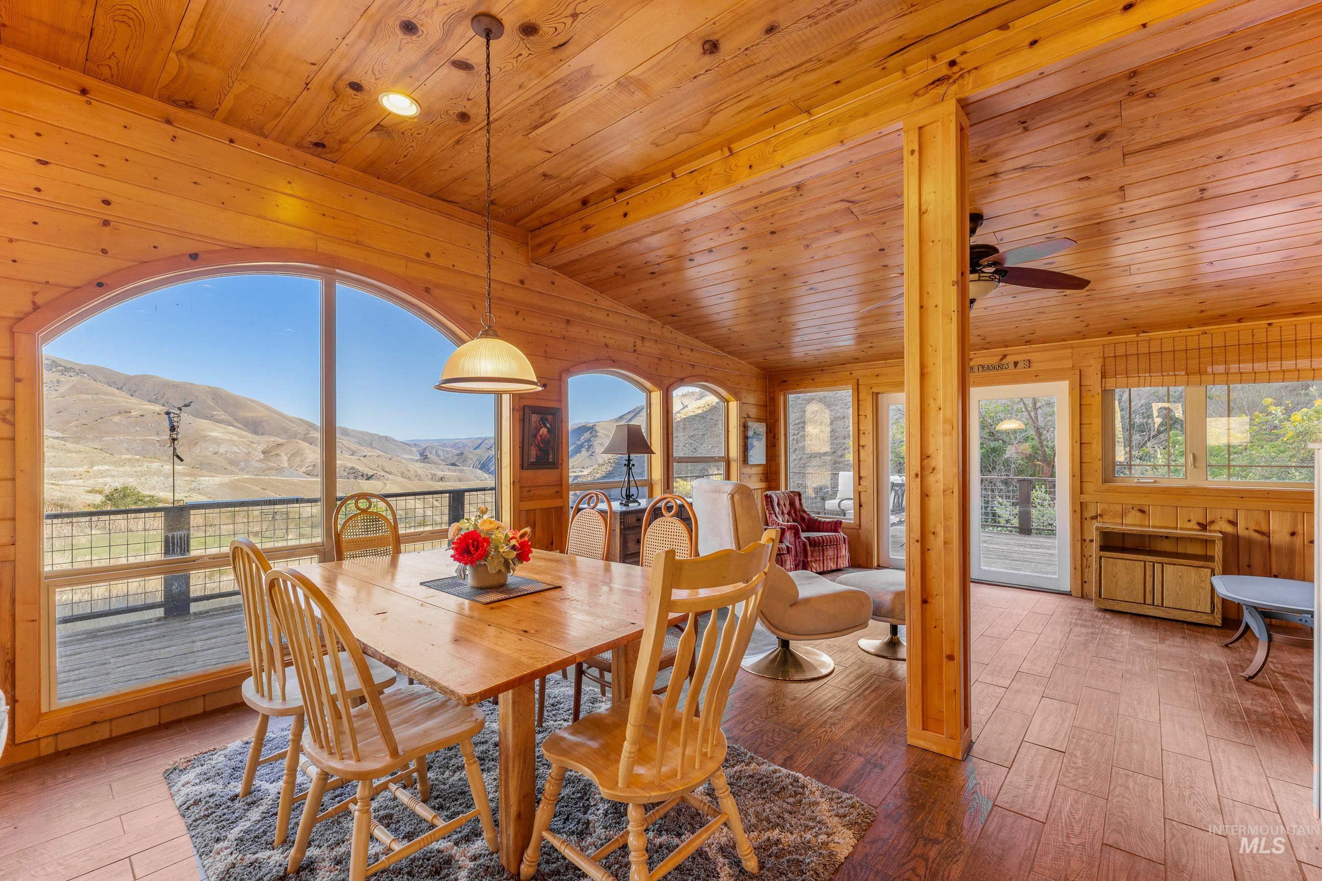 236 Seven U Ranch Road Lucile, ID 83542 - Photo 3 of 26 Dining area featuring a mountain view, wood walls, wood-type flooring, wood ceiling, and lofted ceiling