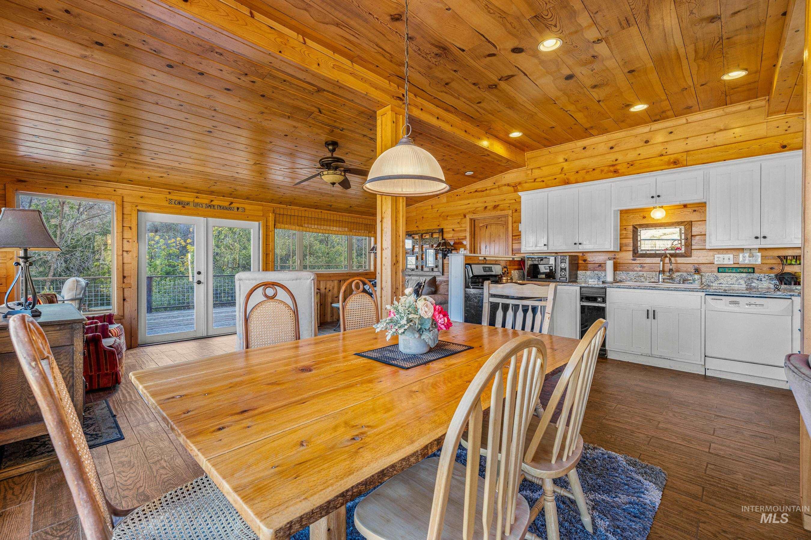 236 Seven U Ranch Road Lucile, ID 83542 - Photo 8 of 26 Dining room with dark wood finished floors, recessed lighting, wood walls, french doors, and ceiling fan