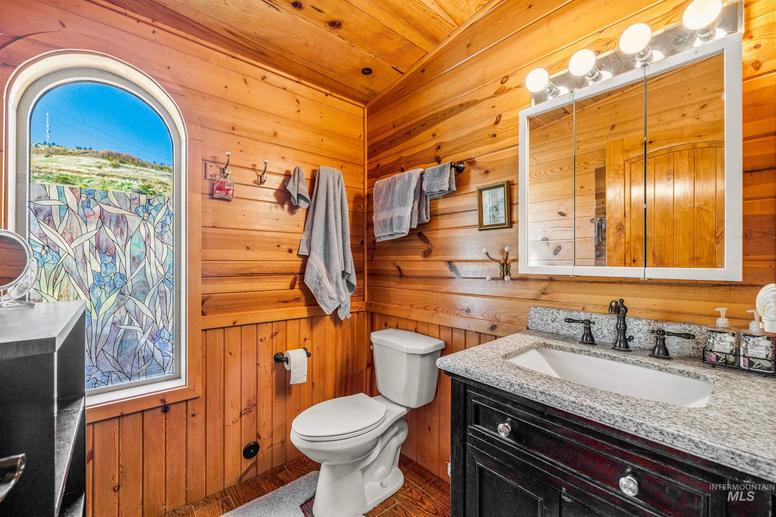 236 Seven U Ranch Road Lucile, ID 83542 - Photo 10 of 26 Half bathroom with wood walls, vanity, and wooden ceiling